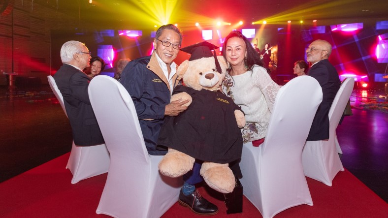 Mr Ho Kwon Ping (front left) and his wife Ms Claire Chiang, with his personalised SMU graduation bear.