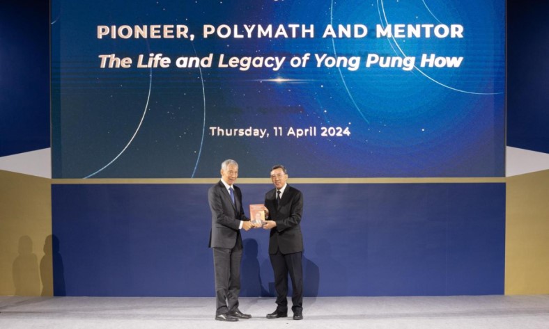 Justice Andrew Phang presenting the newly launched book to Prime Minister Lee Hsien Loong.