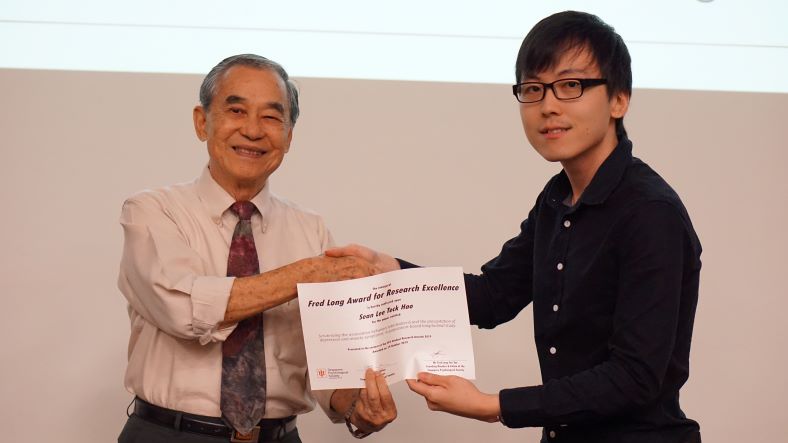 Sean Lee Teck Hao receiving his prize for the Fred Long Award for Research Excellence Award from Dr Fred Long Foo Yee, SPS Founder. Photo Credit: SPS.