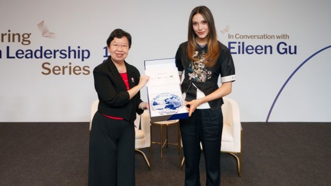 Prof Lily Kong (L) presenting a token of appreciation to Eileen Gu